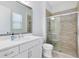 Bathroom featuring a single sink vanity, a large mirror, a toilet, and a glass-enclosed shower at 8480 Adalina Pl, Orlando, FL 32827