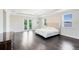 The primary bedroom has dark wood floors, a tray ceiling, and a private balcony with a green view at 8480 Adalina Pl, Orlando, FL 32827