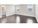Bedroom boasts hardwood floors, neutral walls, and two large windows, plus a door to the ensuite bathroom at 8480 Adalina Pl, Orlando, FL 32827