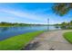 Picturesque lakeside view of the community showcasing well-maintained walking paths and lush landscaping by the water at 8480 Adalina Pl, Orlando, FL 32827