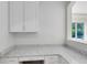 Bright, white kitchen counter space with view to a window with a verdant background at 8480 Adalina Pl, Orlando, FL 32827