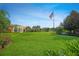Expansive green lawn in front of a luxurious home with a prominent American flag displayed at 8480 Adalina Pl, Orlando, FL 32827
