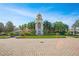 Elegant community building with clock tower, manicured landscaping, and brick-paved entry at 8480 Adalina Pl, Orlando, FL 32827
