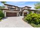 A beautiful two-story home with a three-car garage, barrel tile roof, and paver driveway at 8480 Adalina Pl, Orlando, FL 32827