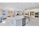 Bright open kitchen with stainless appliances, large island and views of the living room with fireplace at 8480 Adalina Pl, Orlando, FL 32827