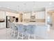 Bright kitchen with white cabinets, stainless steel appliances, granite countertops and four bar stools at 8480 Adalina Pl, Orlando, FL 32827