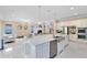 Open concept kitchen with stainless appliances, large island, and seamless flow into the adjacent living area at 8480 Adalina Pl, Orlando, FL 32827