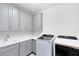 Laundry room features ample storage space, a utility sink, and modern washer and dryer units at 8480 Adalina Pl, Orlando, FL 32827
