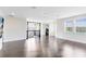 Spacious loft area features dark wood floors, white walls, and natural light from large windows at 8480 Adalina Pl, Orlando, FL 32827