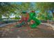 Community playground with green slide, red stairs, and mature trees offering shade at 8480 Adalina Pl, Orlando, FL 32827