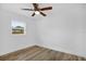 Bright bedroom featuring wood-look floors, ceiling fan and a window with a neighborhood view at 906 Kensington Dr, Orlando, FL 32808
