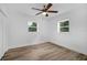 Bright bedroom with two windows, ceiling fan and new flooring offering a fresh, inviting space at 906 Kensington Dr, Orlando, FL 32808
