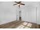 Bright bedroom with a ceiling fan, wood-look flooring and closet with paneled doors at 906 Kensington Dr, Orlando, FL 32808