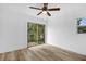 This bright bedroom has a ceiling fan, wood-look floors, and sliding glass doors to the backyard at 906 Kensington Dr, Orlando, FL 32808