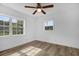 Bright bedroom with wood flooring, ceiling fan, and large windows offering ample natural light at 906 Kensington Dr, Orlando, FL 32808
