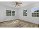 Bright bedroom features a ceiling fan, wood-look floors and two windows with neighborhood views at 906 Kensington Dr, Orlando, FL 32808