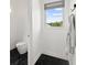 Small bathroom showcasing a modern toilet, neutral colors, and sleek black marble flooring at 9138 Great Heron Cir, Orlando, FL 32836