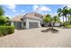 Beautiful exterior shot with large driveway, lush landscaping, and a three-car garage at 9138 Great Heron Cir, Orlando, FL 32836