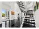 Grand foyer with black tile flooring, modern staircase, and decorative art at 9138 Great Heron Cir, Orlando, FL 32836