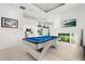 Spacious game room with modern pool table, flat screen TV, recessed lighting, and views of the lake at 9138 Great Heron Cir, Orlando, FL 32836