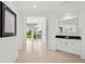 Open hallway with a wet bar and expansive windows showcasing outdoor views and natural light at 9138 Great Heron Cir, Orlando, FL 32836