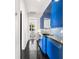 Galley kitchen with a trendy blue color scheme, mosaic backsplash, and sleek appliances at 9138 Great Heron Cir, Orlando, FL 32836