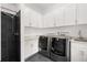 Well-equipped laundry room with modern washer and dryer, sleek cabinetry, a sink, and a shower with black tile at 9138 Great Heron Cir, Orlando, FL 32836
