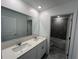 Bright bathroom features a double vanity and an adjoining shower with gray tile at 930 Cattleman St, Winter Haven, FL 33881