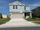 Charming two-story home featuring light blue siding, a spacious driveway, and a two-car garage at 930 Cattleman St, Winter Haven, FL 33881