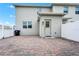 Brick-paved backyard area, adjacent white fencing, and a back door at 9909 Alliteration Aly, Winter Garden, FL 34787