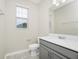 Bathroom featuring a grey vanity and sink with a large mirror and window at 9909 Alliteration Aly, Winter Garden, FL 34787