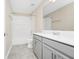 Bathroom with tile floors, a bathtub with white tile surround, and gray vanity at 9909 Alliteration Aly, Winter Garden, FL 34787
