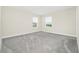 Neutral bedroom featuring two windows and plush gray carpeting at 9909 Alliteration Aly, Winter Garden, FL 34787