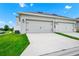 White exterior of a 2-car garage with driveway and adjacent lawn at 9909 Alliteration Aly, Winter Garden, FL 34787