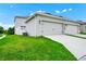 Lawn and exterior view of a 2-car garage with driveway at 9909 Alliteration Aly, Winter Garden, FL 34787
