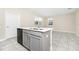 Open kitchen featuring an island with a sink, gray cabinetry, and natural light from nearby windows at 9909 Alliteration Aly, Winter Garden, FL 34787
