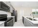 Well-lit kitchen featuring stainless steel appliances, gray cabinets, and a white tile backsplash at 9909 Alliteration Aly, Winter Garden, FL 34787