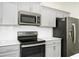 Close-up of a kitchen area featuring stainless steel appliances and light gray cabinets at 9909 Alliteration Aly, Winter Garden, FL 34787