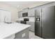 Bright kitchen with gray cabinets, stainless steel appliances, and a large island with a dual sink at 9909 Alliteration Aly, Winter Garden, FL 34787