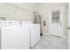 Laundry room with white washer and dryer, utility sink, and storage shelves at 9909 Alliteration Aly, Winter Garden, FL 34787