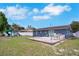 Spacious backyard with a large deck, a playground set, green grass, and a white fence for privacy at 1167 Lake Blanche Dr, Orlando, FL 32808