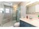 Modern bathroom featuring a glass enclosed shower with a built-in bench and a vanity with a sparkling mirror at 1167 Lake Blanche Dr, Orlando, FL 32808