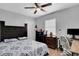 Comfortable bedroom featuring a ceiling fan, a bed with a patterned comforter, and a desk for work or study at 1167 Lake Blanche Dr, Orlando, FL 32808