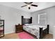 Cozy bedroom with a ceiling fan, wood floors, a bed with a patterned comforter and a plush pink rug at 1167 Lake Blanche Dr, Orlando, FL 32808