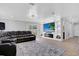 Living room featuring a large television built-in, gray walls, and black leather sofa with backyard access at 1167 Lake Blanche Dr, Orlando, FL 32808