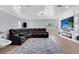 Living room with a comfortable black leather sectional, patterned area rug, and entertainment center with a large television at 1167 Lake Blanche Dr, Orlando, FL 32808