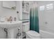 Bright bathroom featuring a pedestal sink, toilet, and shower/tub combo with a stylish teal shower curtain at 1328 Vassar St, Orlando, FL 32804