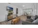 Open-concept living room and dining area featuring hardwood floors, a modern entertainment center, and plenty of natural light at 1328 Vassar St, Orlando, FL 32804