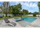 Beautiful backyard pool with a sun shelf and spillover spa, surrounded by lush landscaping and an enclosed fence at 1328 Vassar St, Orlando, FL 32804