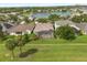 An aerial view of backyard featuring screened lanai, lush lawn, and tranquil water view at 14016 Fox Glove St, Winter Garden, FL 34787